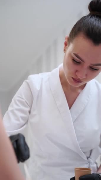 美容师专注于准确的凝胶确保病人的舒适性 有效的激光治疗 理发专家准备激光脱毛程序 在临床应用于客户皮肤的预处理凝胶 — 图库视频影像