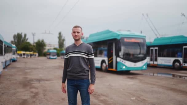 Mladý Profesionální Řidič Pousmáním Neformálním Oblečení Stojí Parkovišti Trolejbusu Zkříží — Stock video