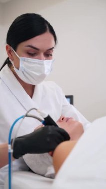 Hidratsal yenilenme, gözenekleri temizleme, kaplıcada yüzü sulandırma. Estetisyen, parlayan deri için müşteriye hidro dermabrasyon uyguluyor. Yaşlanmayı önleme amaçlı güzellik tedavisi, ten rengini tazeler.