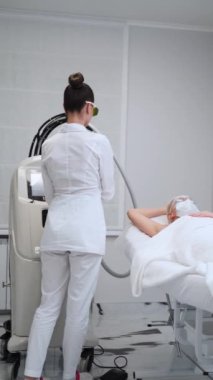 Müşteri kıllarını aldırma prosedüründen geçiyor. Klinikte uzman biri tarafından yapılan lazer epilasyon tedavisi. Pürüzsüz cilt için profesyonel estetik hizmeti. Cilt bakımında yüksek teknoloji kozmetik yeniliği.