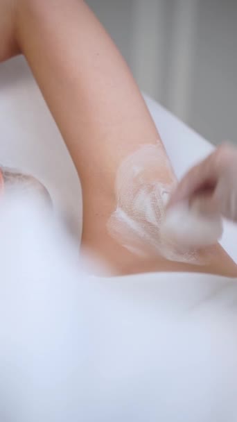 レーザー治療後 腕はクリニックの設定で水和クリームアプリケーションを受け取ります スキンケアのルーチンは 皮膚を磨き 癒しを促進する エステティシャンが適用されます エステティシャン 毛の取り外しのスキンケア — ストック動画