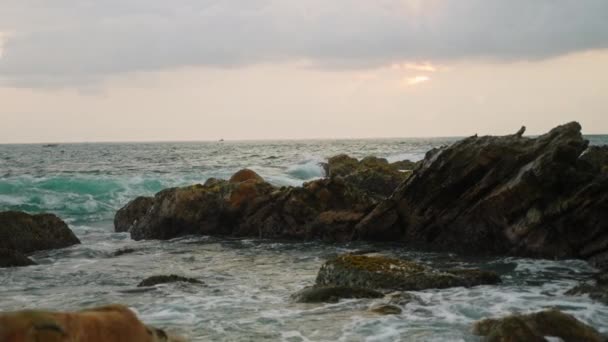 乱れた海を見下ろす灯台のある熱帯の海岸線 自然愛好家のためのセレンシースケープビデオ トラベルブッグ 岩の海岸線の上に日の出 波はボールダー 海鳥の周りに衝突する — ストック動画