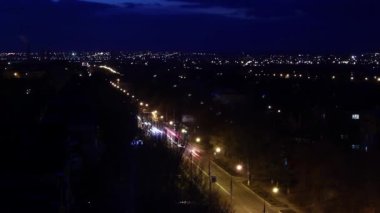 Karanlık çöktüğünde, dinamik şehir hayatı yüksekten çekilmiş. Gece şehir manzarası şehir ışıklarının yanıp söndüğünü, caddelerin araçlarla hareketlendiğini, hayatın hızlı ilerlediğini gösteriyor..