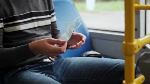 Jonge Mannelijke Passagier Reist Trolleybus Haalt Gezichtsmasker Uit Zijn Tas — Stockvideo