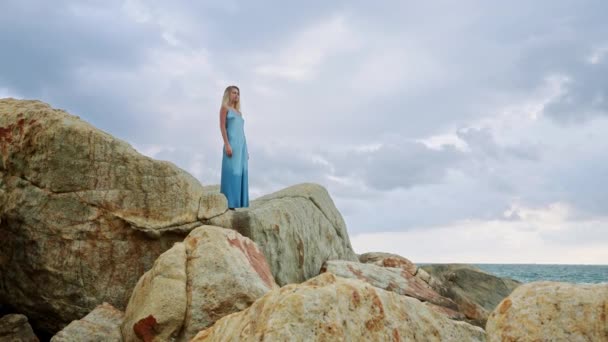 自然における孤独は 精神的回復 中毒療法を助長する 青いドレスの女性は静けさのために海辺の崖に立っています 沿岸の風景シーンは 内なる平和 強力な癒しの環境を意味する — ストック動画