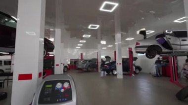 Teknisyenler araba tamiri, bakım, teşhis, parlak LED ışıkları altında temiz garajda. Oto tamircileri modern araba servisinde araçlar üzerinde çalışırlar. Tamirhane içi, ekip iş başında..