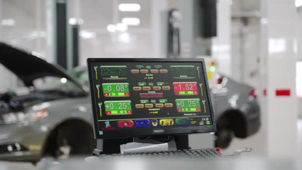 修理場所の現代研修会の車の維持のための使用の精密診断用具 自動サービス技術はリフトの車を調節している間コンピュータ スクリーンの車輪のアライメントを監視します — ストック動画
