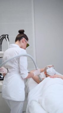 Kadın, yumuşak cilt için gelişmiş ekipmanlarla profesyonel koltuk altı epilasyonu alıyor. Yetenekli estetisyen klinikteki müşterilerine lazer tüyü temizliği yapıyor. Estetik teknolojisi güvenli vücut bakımını sağlar.