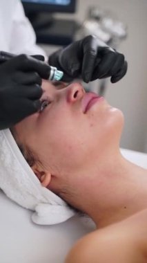 Estetisyen, su soyma cihazı kullanarak cilt bakımını, cilt bakımını, cilt bakımını, gözenekleri ve su kaynaklarını temizler. Müşteri kaplıcada cilt gençleştirme tedavisi görüyor..