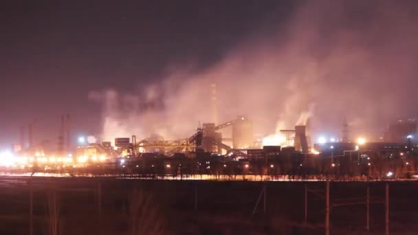 夜間のマリポールスチール工場の工業用タイムラプス 輝く炉 煙突の排出の封筒の空 都市インフラ前景 ウクライナの重工業のエコインパクトの焦点 — ストック動画