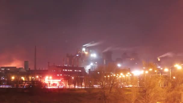 夜間のマリポールスチール工場の工業用タイムラプス 輝く炉 煙突の排出の封筒の空 都市インフラ前景 ウクライナの重工業のエコインパクトの焦点 — ストック動画