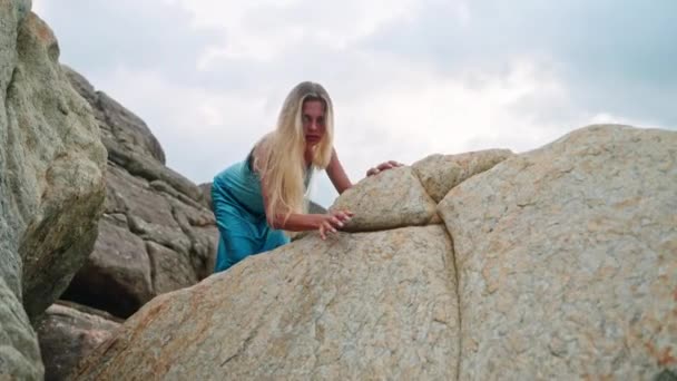 ファッション ワイルドなラグジュアリーテーマ エンパワーメントストーリーにフィットするビデオコンテンツ アジールガウンでエレガントな女性は岩の地形を登り 生存のテーマを紹介し 自然に訴え 強さの優雅さ — ストック動画