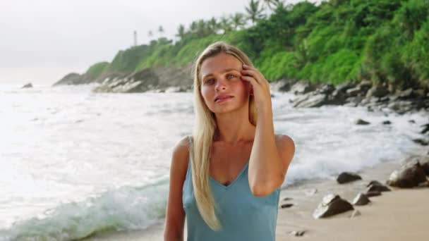 드레스에서 바람을 즐긴다 여자는 선크림 해변을 적용합니다 Sunblock 이국적인 해안에서 — 비디오