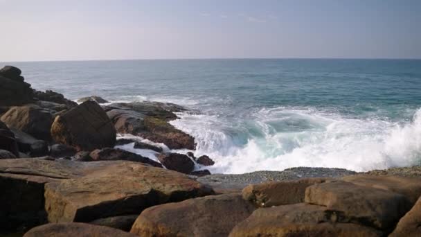 自然なリズムでシースケープ スプレーが上昇します 海の波が岩の海岸線に衝突する 沿岸のボールダーはサーフに会い 白い泡を作ります 自然の背景を再現する ウェルネスビデオニーズに最適 — ストック動画