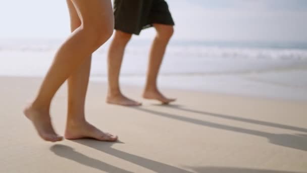 有冲浪板的人走在潮湿的沙滩上 低角度的视野 冲浪者们赤着脚在潮湿的沙滩上冲浪 热带岛屿上的男人 女人在海浪中冲浪的脚印 — 图库视频影像