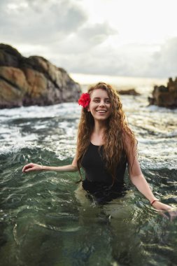 Kadın, egzotik plaj tatiline ve ılık okyanusta dinlenmeye bayılır. Kızıl saçlı kadın gün batımında denizde yüzer. Bayan sakin bir tropikal inzivaya çekiliyor, yoğun yaşamdan kaçıyor. Boş zaman, doğa..