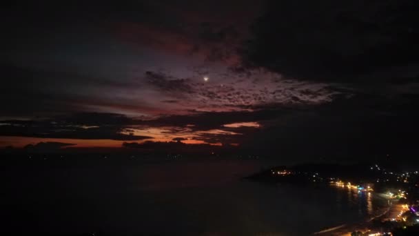 暮光反射在海洋中 云彩变换颜色 具有戏剧性的日落天空在沿海城市景观的上空快速发展 夜晚的城市海岸 从上空捕捉到的快速黄昏到夜晚的过渡 — 图库视频影像