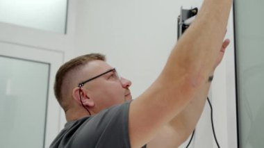 Modern diş kliniğinde hasta fotoğrafı çekmek için ışıklandırma ekipmanı hazırlayan erkek dişçiye yakın çekim. Fotoğrafçı yumuşak kutuyu tamir ediyor. Doktor ateş etmeden önce ışığı hazırlar. Kozmetik dişçiliği.