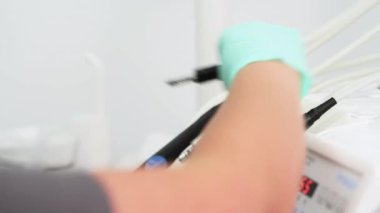 Dişçilerin elleri lateks eldivenli steril diş aletleri hazırlıyor. Hemşire stomatoloji steril aletle çalışıyor. Modern tıp kliniğinde diş tedavisi için metal aletler. Yakın plan..