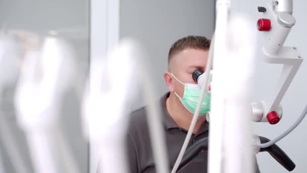 Männlicher Zahnarzt Behandelt Patienten Unter Dem Mikroskop Einer Modernen Zahnarztpraxis — Stockvideo