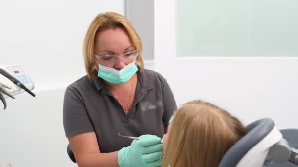 Pediatrisk Kvinnlig Tandläkare Behandla Små Flickor Tänder Moderna Tandläkarmottagning Stomatolog — Stockvideo