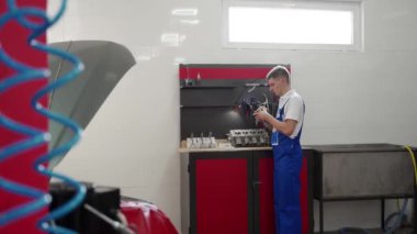 Uzman pistonlara uyar, halkalar takar ve atölyede replik hazırlar. Profesyonel tamirci motoru titizlikle monte eder. Motor onarım işlemi gösterildi, beceri ve verimlilik gösterildi.