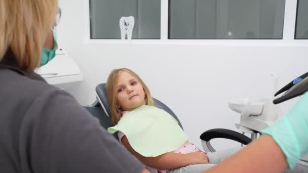 Liten Flicka Sitter Tandläkare Stol Modern Tandläkarmottagning Kvinnlig Tandläkare Justeringsstol — Stockvideo