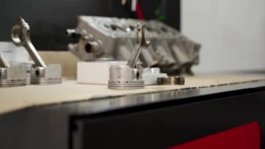 Oto tamircisi motor bileşenleri yeniden inşa eder. Motor elden geçirme süreci silindir başı, pistonlar, yüzükler, çalışma tezgahındaki doğrular üzerinde yoğunlaşarak gösterildi. Otomotiv tamiri, montaj parçaları, bakım sergilendi.