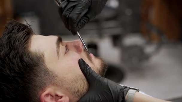 专业的造型师在沙龙里为男人准备胡子和卫生习惯 理发师使用剃须凝胶 为男性顾客准备美容护理 男士仪容护理 城市理发店设置 — 图库视频影像