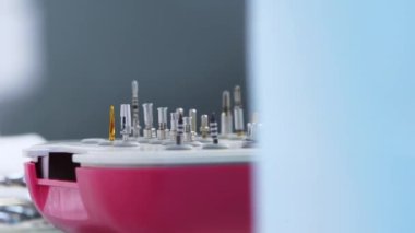 Diş aletleri için dişçi ofisindeki masada metal başlıklar var. Tıbbi masaya diş implantı yerleştirmek için stomatoloji araçları. Dişçilikte steril aletler. Makro, yakın plan..