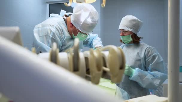 男牙外科医生 护士在手术室做根管手术 现代牙科诊所的内科医生和辅助手术病人 口腔手术 牙科植入物的安装 — 图库视频影像