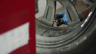 Hassas hizalama, dönüş testi, denge kontrolü güvenli sürüş sağlar. Otomobil tamircisi garajda tekerlek dengeleyicisinde araba lastiğini dengeliyor. Araç bakımı, lastik bakımı, atölye servisi, tamirat çalışmaları.