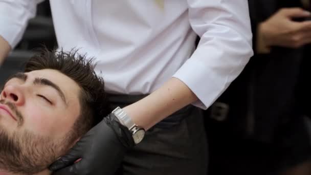 专业按摩师在手套护肤客户 加强护肤 促进放松 在理发店温泉疗养院接受专业的面部按摩 现代男性仪容整洁 健康治疗课程 — 图库视频影像