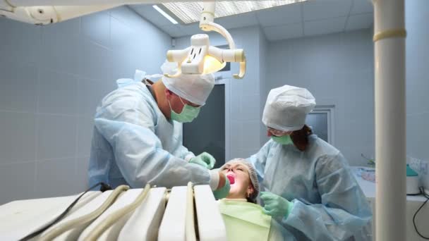 手術室でルート運河で医療活動をしている 外科医です 歯科医は 現代の歯科医院で手術後にガムにステッチを入れています 歯科手術 歯科インプラントの設置 — ストック動画