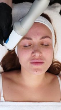 Uzman, yaşlanma karşıtı tedavi uyguluyor, cilt esnekliğini arttırıyor, gevşek müşteride kırışıklık azaltma yapıyor. Kadın modern klinikte yüz gençleştirme terapisi görüyor. Güzellik, cilt bakımı.