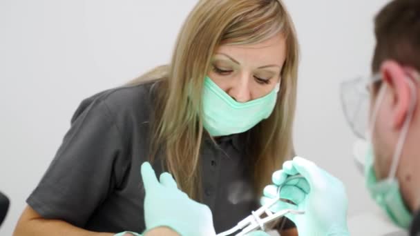 Kvinnlig Assistent Manlig Tandläkare Ansiktsmasker Arbetar Modern Tandvårdsklinik Sjuksköterska Stomatolog — Stockvideo