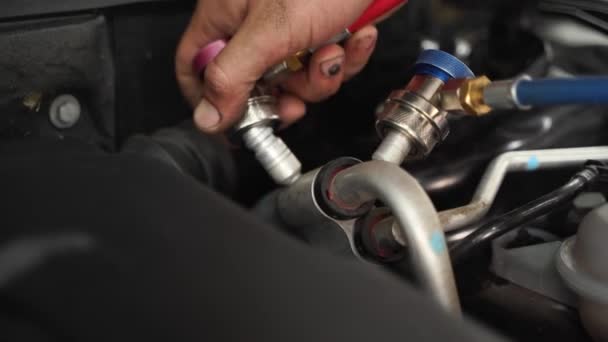 用于冷却系统维护的Hvac专业技术手段 汽车修理工连接汽车交流充电用的软管 维修车间配备有专家工作人员的车辆空调机 — 图库视频影像