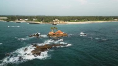 Issız sakin bir tatil ve balayı kaçışı için mükemmel bir yer. Issız bir ada evi okyanus dalgalarının ortasında duruyor. Drone görünümü tenha mimariyi, doğal güzelliği, sahil cazibesini ön plana çıkarıyor.