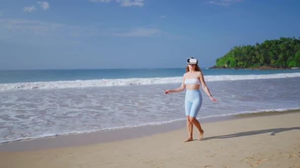 여성은 세계를 탐험하고 화창한 해변에서 헤드셋을 착용하고 환경을 경험하며 디지털 — 비디오