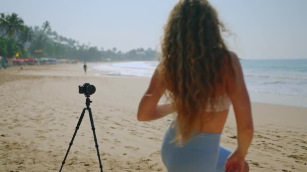 阳光明媚的海滨为精力充沛的表演提供了优美的背景 非常适合健身和旅游 卷发女子在社交媒体上记录海滩舞步 — 图库视频影像