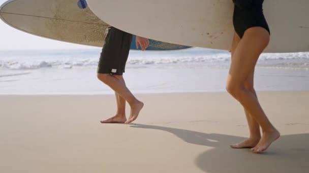 Люди Досками Серфинга Выходят Мокрый Песок Вид Сбоку Низким Углом — стоковое видео