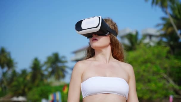 Donna Esplora Mondi Virtuali Con Auricolari Sulla Spiaggia Tropicale Immersi — Video Stock