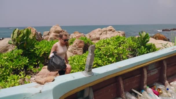 봉사자는 폐기물을 서식지를 여자는 해안을 쓰레기를 버려진 플라스틱 병으로 채우는 — 비디오