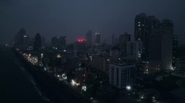 Sri Lanka başkentinin şehir silueti, binalar, şehir ışıkları ışıldıyor. Colombo şehir manzarası, aydınlık sokaklar, yüksek binalar, görünen kıyı şeridi. Seyahat ve şehir planlaması için ideal.