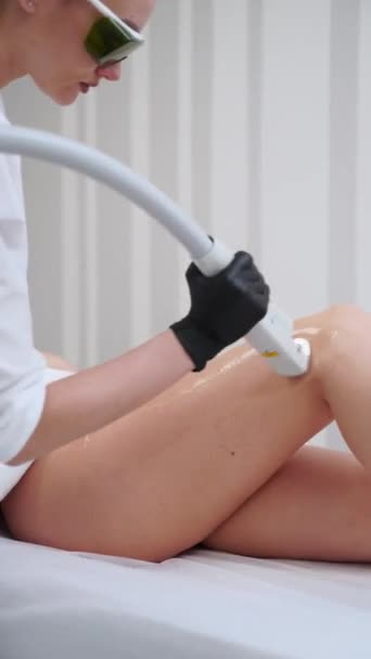 환자는 화장품 절차에 거짓말 스킨케어 전문가가 클라이언트 다리에 레이저 제거를 — 비디오