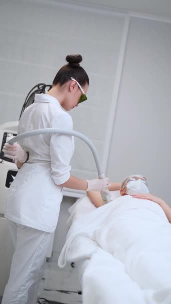 专业的美学程序 客户躺下 护目镜 在诊所里由熟练的治疗师进行激光脱毛治疗 白色洁净室内的永久性脱毛工艺 — 图库视频影像