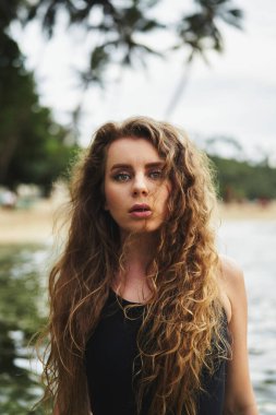 Okyanus dalgaları banyo yapar, rahatlar, yaz havası yaratır. Çekici bir kadın plajda yüzmekten hoşlanıyor. Odaklanma refahı. Mayo mankeni, kıvırcık saçlar, dingin doğa. Uygun yaşam tarzı, su egzersizi, kıyı özgürlüğü..