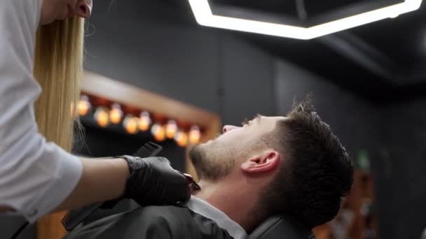 エキスパートの美容師は トレンディなメンズヘアスタイルのためのクリッパー ハサミを使用しています プロの床屋は現代サロンで男性の顧客にスタイリッシュなヘアカットを与えます グルーミングセッション 精密なヘアカット — ストック動画