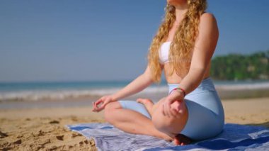 Kadın plaj meditasyonu için VR kulaklık kullanıyor, dingin bir ortama sanal gerçeklik taşımacılığı, kumlu kıyılarda gevşeme teknolojisi sağlık uygulaması.