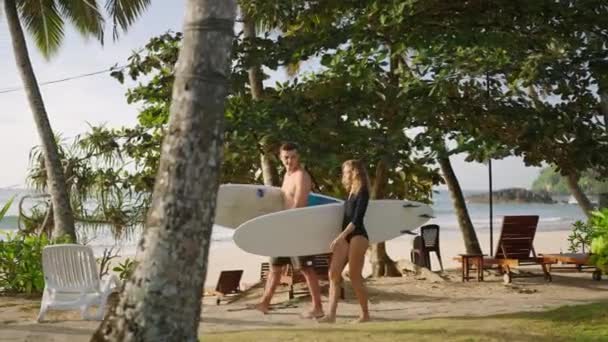 Romantyczna Para Deskami Surfingowymi Idąca Kierunku Fal Oceanicznych Wśród Zielonych — Wideo stockowe